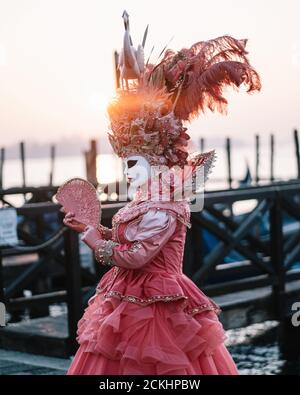 Costume/maschera carnevale tradizionale che posa la mattina presto sul lungomare durante un alba al carnevale annuale a Venezia, Italia Foto Stock