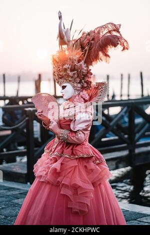 Costume/maschera carnevale tradizionale che posa la mattina presto sul lungomare durante un alba al carnevale annuale a Venezia, Italia Foto Stock