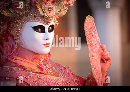 Costume/maschera carnevale tradizionale che posa la mattina presto sul lungomare durante un alba al carnevale annuale a Venezia, Italia Foto Stock