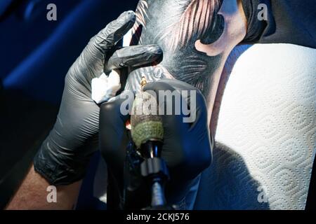 Foto di tatuatore che fa tatuaggio nero di serpente per la donna Foto Stock