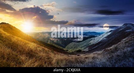 giorno e notte cambiare idea sopra il paesaggio di montagna in autunno. asciutto erba colorata sulle colline. cresta dietro la valle lontana con sole e mo Foto Stock