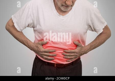 Mal di stomaco, uomo che mette le mani sull'addome isolato su sfondo grigio parete Foto Stock
