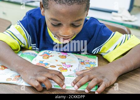 Miami Florida,Frederick Douglass Elementary School,Inside primary,low income community,Black Student students people boy classic desk lettura libro Foto Stock