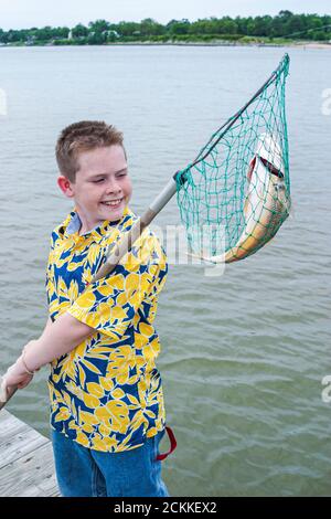 Newport News Virginia, James River Water, pesca ragazzo bambino rete pescato pesce tenendo ricreazione, molo visitatori vacanza persone persona scena foto Foto Stock