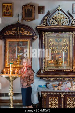 MURMANSK RUSSIA - 2014 SETTEMBRE 14. Donna russa con le candele nella Chiesa del Salvatore sulle acque. Foto Stock