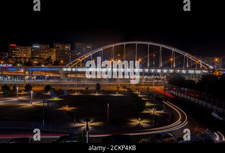 Sochi, Russia - 11 settembre 2020: Moderno ponte stradale e treni vicino alla stazione ferroviaria in Adler vista notturna. Foto Stock