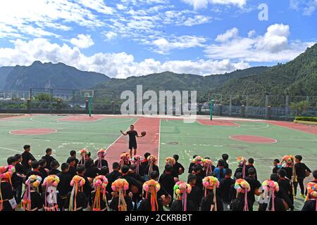 (200915) -- LINGYUN, 15 settembre 2020 (Xinhua) -- Shen Yequan (Top) dà una classe di pallacanestro per gli studenti della scuola elementare di Lanjin nel comune di Sicheng della contea di Lingyun, regione autonoma di Guangxi Zhuang della Cina meridionale, 8 settembre 2020. Shen, di 28 anni, è l'unico insegnante di PE della scuola del villaggio. È stato assegnato per insegnare l'istruzione fisica nella scuola in 2018 dopo la laurea con una laurea in sport. "A causa dei nostri sforzi inarrestabili, i bambini hanno un forte desiderio di attività fisiche. Mi attendo al mio posto qui per aiutare i bambini rurali a coltivare l'abitudine di partecipare allo sport Foto Stock