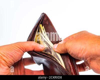 Le mani contano i dollari americani di soldi in un portafoglio dell'uomo. Foto Stock