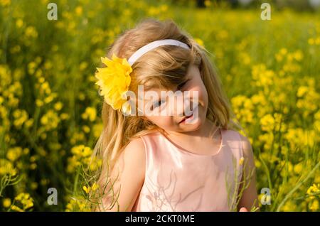 ritratto di bella ragazza bionda in campo di colza Foto Stock