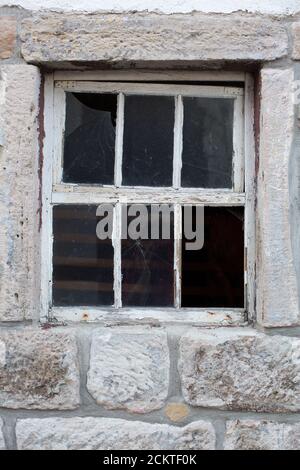 Vecchia finestra in un muro di pietra massiccio Foto Stock