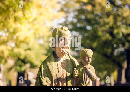 statue di pietra tra tombe nel cimitero Foto Stock