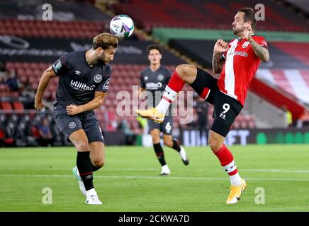 Charlie Goode di Brentford (a sinistra) è a capo del premio di palla da Danny Ings di Southampton durante la seconda partita della Carabao Cup al St Mary's Stadium di Southampton. Foto Stock