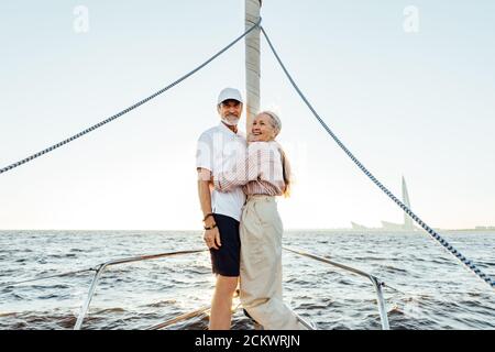 Due persone anziane in casual in piedi su yacht prua e. sorridente Foto Stock