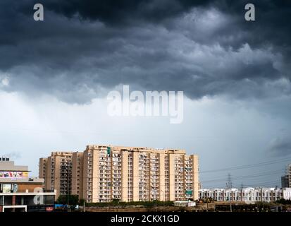 il paesaggio urbano di gurgaon delhi con le nuvole monsonone che gettano ombre in alto sorgono appartamenti ed edifici che mostrano il passare del tempo e rapidamente crescita di reale Foto Stock