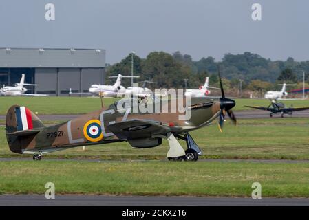 Hawker Hurricane e Supermarine Spitfire che tassano a Biggin Hill dopo il volo del Battle of Britain Day Anniversary, con jet d'affari parcheggiati Foto Stock