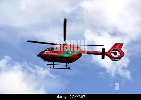 Pontypridd, Galles - Marzo 2018: Un elicottero Airbus del servizio di ambulanza aerea del Galles sullo sfondo di un cielo blu e nuvole bianche. Foto Stock