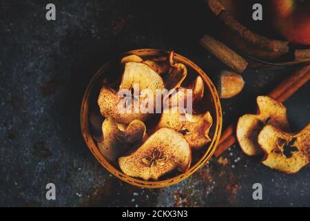 Patatine di mele cotte in casa su sfondo scuro moody, fuoco selettivo Foto Stock