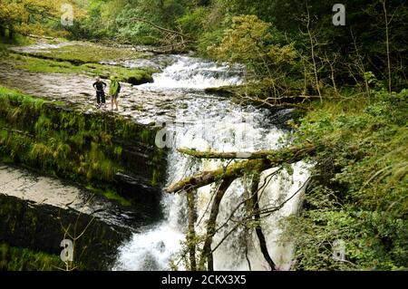 Brecon Beacons National Park, Galles - 2017 agosto: Due escursionisti sul bordo della cascata 'strad Clun-Gwyn' che significa 'caduta del prato bianco' Foto Stock