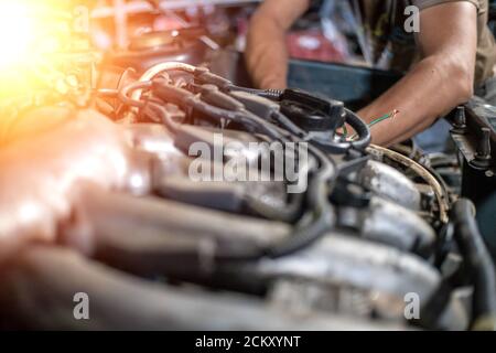 mani di meccanico che riparano il primo piano del motore della vettura, foto con illuminazione, luce Foto Stock