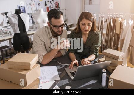 Team Seamstes pronto a spedire il pacchetto al cliente con abiti nuovi Foto Stock