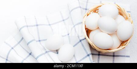 uova di pollo su un tovagliolo da cucina controllato su un tavolo leggero. concetto di prodotti agricoli e alimenti naturali. Articolo sui prodotti domestici. Uova di pollo fresche . Foto Stock