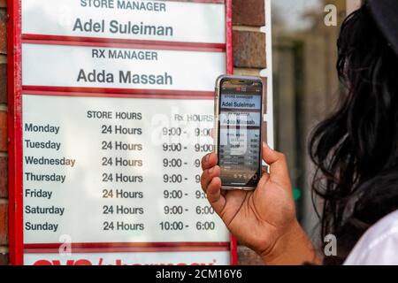 Washington, DC, USA, 16 settembre 2020. Nella foto: Un protesto mostra il nome del manager CVS mentre si riproduce in streaming in diretta su Instagram da una protesta al Wisconsin Avenue CVS. La protesta si è svolta perché il giorno prima, il responsabile del negozio CVS ha chiamato la polizia circa due 'maliziosi' uomini neri. Sei funzionari della polizia metropolitana (DC) hanno arrestato i due uomini, alla fine rilasciandoli dopo una ricerca non ha trovato oggetti rubati. Dato il notevole rischio di violenza quando la polizia viene chiamata contro gli uomini neri, un certo numero di persone è venuto a protestare la decisione del direttore. Credito: Allison C Bailey/Alamy Foto Stock