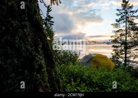 Tenda da campeggio sulla riva del lago in serata Foto Stock