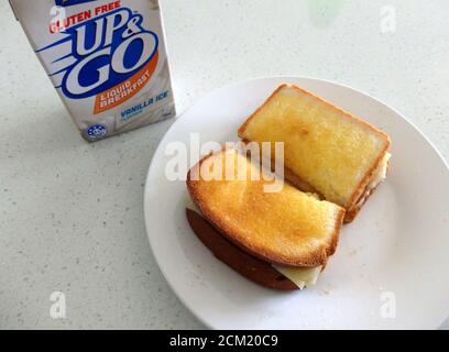 Un pranzo senza glutine con un panino di formaggio tostato senza glutine e una bevanda. Foto Stock