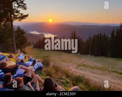 I giovani si rilassano, guardando il tramonto in montagna, sul lago Belis, a Marisel, Cluj contea, Transilvania, Romania. Attività all'aperto nella natura w Foto Stock