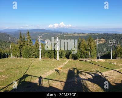 La pista sciistica di Marisel e il lago di Belis in estate nella giornata di sole, Romania. Appuseni scena montagne, Cluj contea, Transilvania, Romania. Pineta, bianco Foto Stock