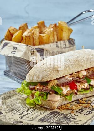 Panino Philly Steak. Classico panino americano con un tocco di originalità. Ciabatta pane-rotolo ripieno con fette di bistecca di groppa su foglie di insalata verde, rosso e verde Foto Stock