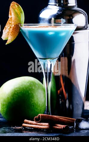 Cocktail con liquore, crema e mela verde, strumenti da bar su sfondo nero, concentrazione selettiva Foto Stock