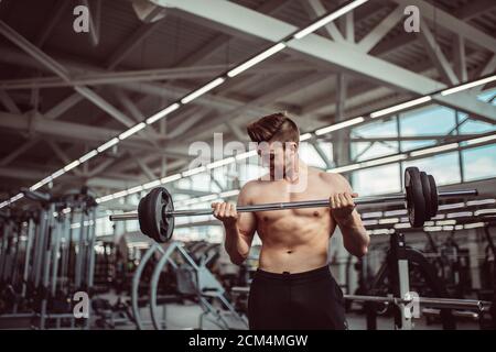 Forte barbuto uomo caucasico ad una palestra crossfit sollevamento di un barbell. Foto Stock