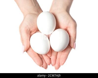 Mani donna con uova bianche isolate su sfondo bianco, concetto Foto Stock