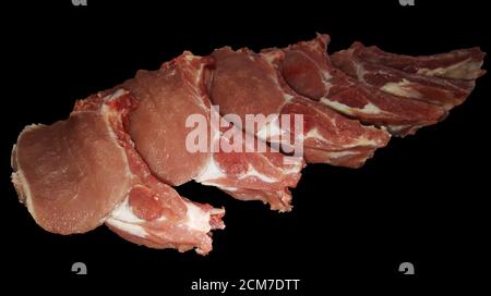 foto di filetto di maiale isolato su una costola tagliata pezzi su una tavola su sfondo nero Foto Stock