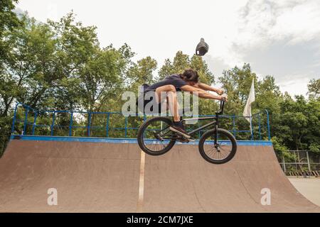 Bmx rider esecuzione di salto a rampa su skatepark Foto Stock