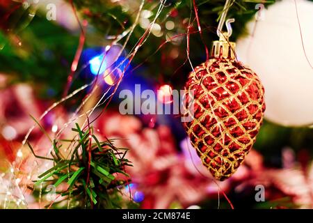 Cono rosso luminoso appeso su un ramo di un albero di Natale. Texture di sfondo festive Foto Stock
