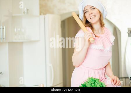 Bella giovane donna che cucina in casa cucina Foto Stock