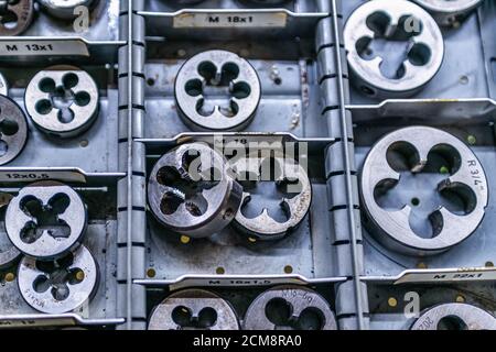 Utensile per stampi di taglio a filettatura di dimensioni diverse, un primo piano fotografico. Contesto astratto industriale. Foto Stock