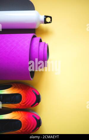 Tappeto da yoga viola brillante e bottiglia d'acqua Foto Stock