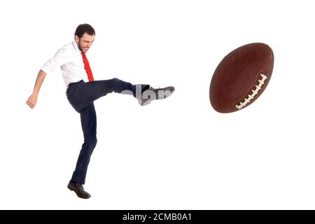 Businessman kicking aa americano calcio palla o rugby palla isolato in bianco Foto Stock