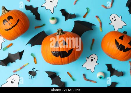 Halloween Concept con zucche, fantasmi, caramelle e pipistrelli su sfondo blu Foto Stock