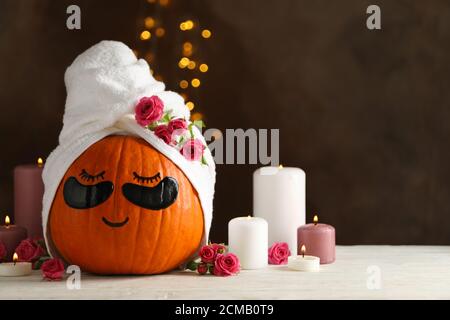 Candele e zucca con macchie sugli occhi su sfondo marrone Foto Stock