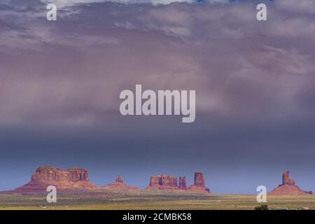 Monument Valley famoso paesaggio arido di sabbia rossa con eccezionali rocce geologiche buttes e mesas sotto la nuvola pesante nello Utah USA. Foto Stock