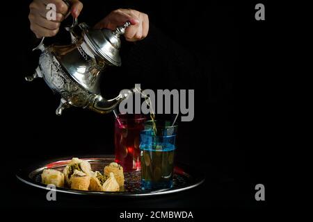 Persona che serve il tè sulla teiera araba Foto Stock