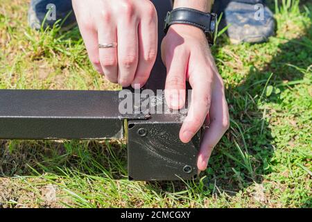 Lavoro con un utensile manuale che monta la costruzione di metallo all'aperto Foto Stock