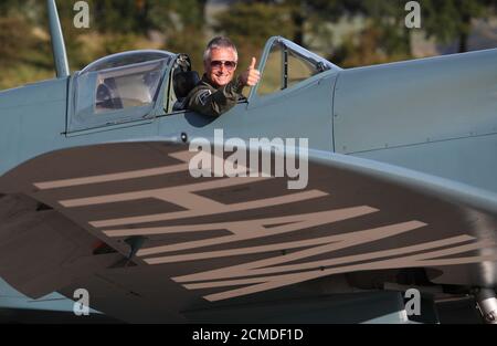 Il pilota John Romain con lo Spitfire 'Thank You NHS' all'aeroporto di Cumbernauld prima di volare sugli ospedali scozzesi per raccogliere denaro per le associazioni di beneficenza NHS. I membri del pubblico possono donare denaro per avere un nome di un amato scritto sul corpo dell'aereo, con i proventi che vanno a beneficenza NHS insieme. Foto Stock