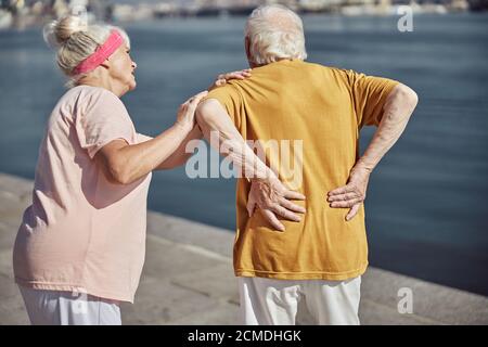 Uomo caucasico anziano che soffre di neuralgia lombare Foto Stock