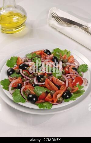 Insalata di pomodoro con olive, capperi e coriandolo Foto Stock