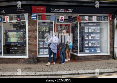 Le famiglie che guardano alle finestre degli Agenti immobiliari mentre sono in vacanza a Dartmouth, South Hams, Devon, Inghilterra, Regno Unito Foto Stock